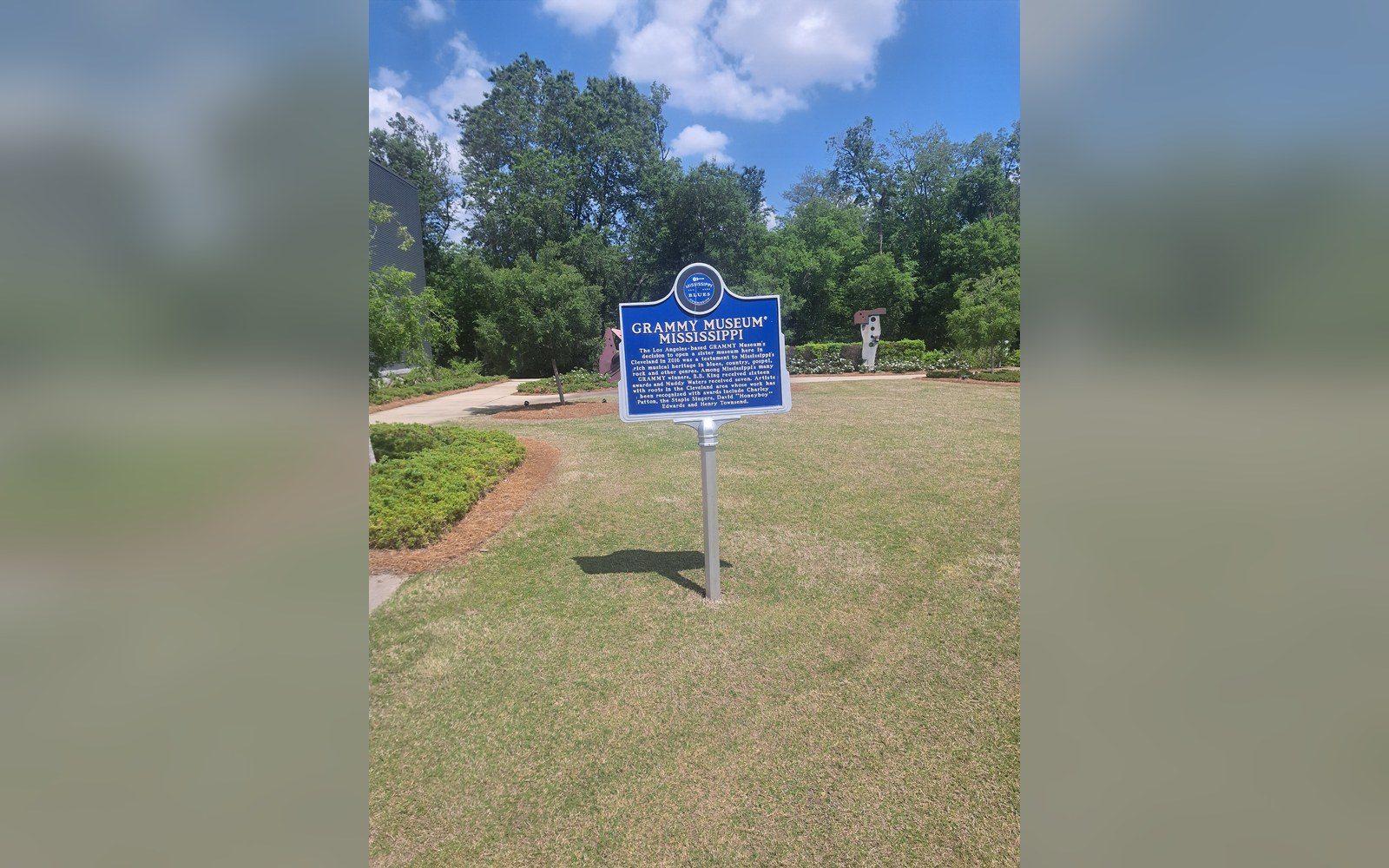 Blue historical marker for the Grammy Museum Mississippi on a grassy lawn